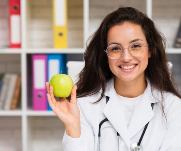 front-view-smiley-doctor-with-apple_23-2148302118