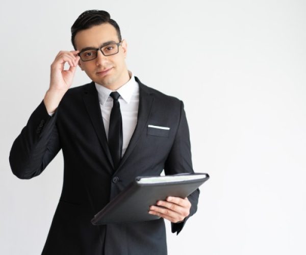 serious-handsome-young-businessman-adjusting-glasses-holding-folder_1262-14365